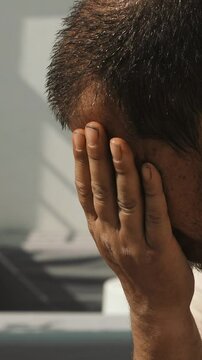 Vertical: A man struggles in the sweltering summer heat, sweating profusely as the temperature soars
