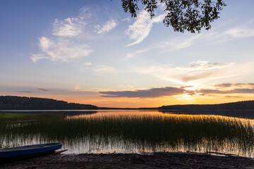 A tranquil lake view during sunset featuring peaceful reflections