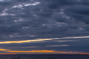 Coastal landscape photo featuring dark cloudy sky over the horizon