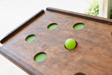Engaging gameplay with a vibrant green ball on a wooden arcade table