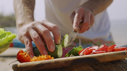 A man is cutting vegetables on a wooden cutting board. The vegetables include radishes, peppers, and onions. The man is using a knife to cut the vegetables into small pieces. The scene has a calm