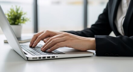 Woman typing on laptop keyboard at office desk. Businesswoman hands at computer. Online work and remote communication.