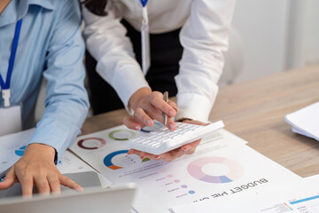 Financial Planning and Analysis. Women calculating budget in a collaborative office setting.
