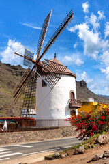 Historic windmill "Molino Quemado" in Mogan with mountain backdrop, Gran Canaria, Spain