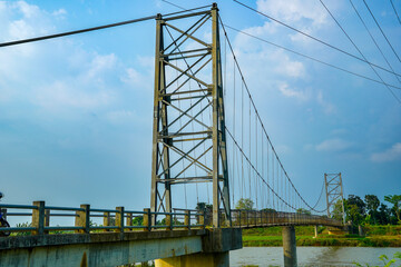 view from the iron suspension bridge crossing the river with a clear sky background for advertising space.