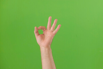 Male Hand Making OK Sign with Fingers. Man Fist Showing Victory Symbol Gesture Isolated against Chroma Key Green Screen Background. Body Language. 4K Footage. Close Up. Everything is Good. Proposing