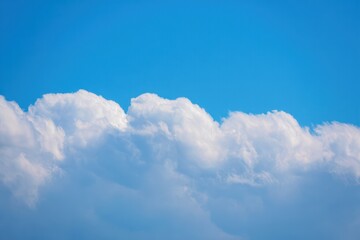 Fluffy white cumulus clouds against a clear blue sky evoking calm and peaceful atmosphere