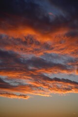 Fototapeta premium dramatic sky with vibrant orange and dark blue clouds at sunset creating a moody and awe-inspiring atmosphere