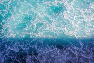 Obraz premium Aerial view of turquoise ocean water with white foam and waves creating intricate patterns under soft natural light