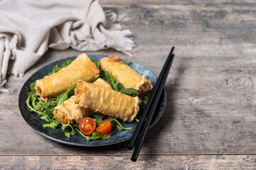 Crispy vegetables spring Rolls on wooden table. Copy space
