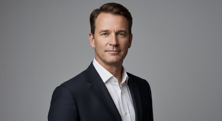 Caucasian business man in suit on gray background. Male executive standing. Professional portrait for corporate and finance.