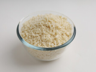 White breadcrumbs or panko flour in a glass bowl isolated