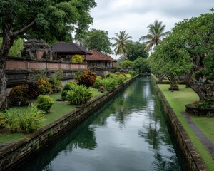 Obraz premium Waterway lined with lush greenery and traditional architecture.