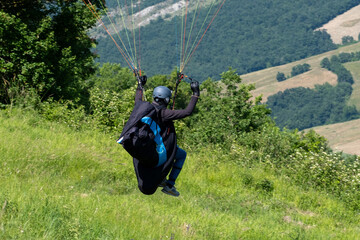 Sestola, Italy – 05 31 2025: Paraglider flies in the air. Aerial view of paragliding. Paraglider...