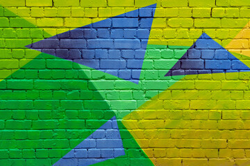 Vivid geometric street art mural with green, yellow, and blue triangles painted on brick wall brings energetic, urban style to modern backgrounds.