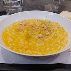 Risotto with pumpkin, rosemary, biscuits, cheese in a white plate on the table, close-up. Italian cuisine