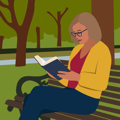 A woman with glasses sits on a bench in a park and reads a book against the background of trees