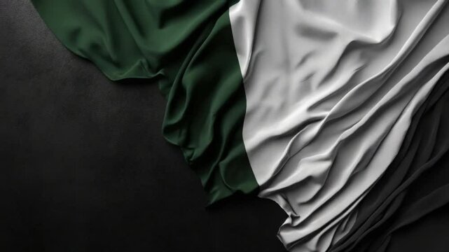 Elegant Fabric: Green and White Silk Texture Flowing Against a Dark Backdrop