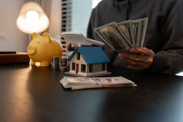 a man is calculating the money from his savings account to buy a house, this man is calculating his...