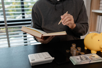 a man is calculating the money from his savings account to buy a house, this man is calculating his...