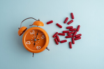 Time to take pills. Alarm clock shows time to take medicine. Taking vitamins or medicine. Concept of health care, medicine, pharmacy, disease prevention