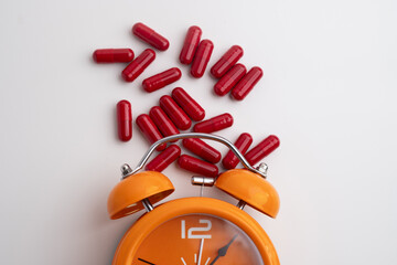 Time to take pills. Alarm clock shows time to take medicine. Taking vitamins or medicine. Concept of health care, medicine, pharmacy, disease prevention