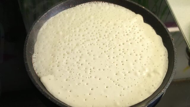 pancake is fried in a hot frying pan