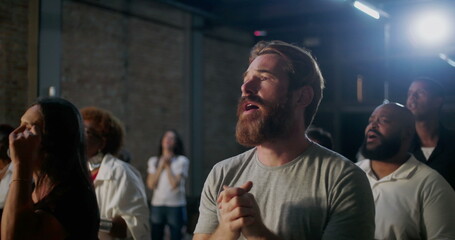 Congregation in church expressing faith and devotion through prayer, raising hands in worship near...