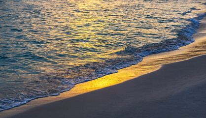 reflection of the colors of a sunset the surface of the water on a beach on the island