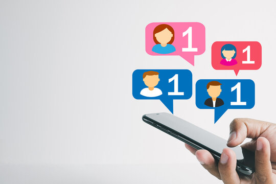 Hand holding smartphone with vibrant social media notification or new friend icons on white background Concept for social media,engagement,instant messaging, digital marketing,digital communication.