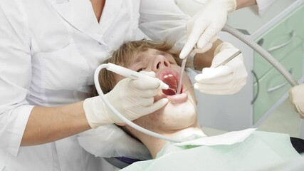 Young patient receives a dental check-up in a modern clinic, with professionals examining and treating oral health - Powered by Adobe