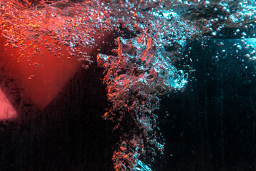 water texture rumbling chaos with bubbles created by air escaping outside in blue and red light