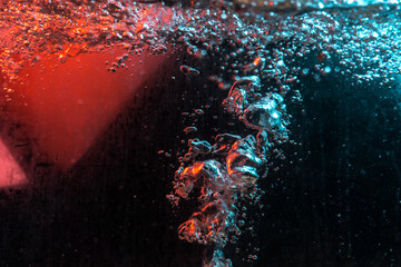 water texture rumbling chaos with bubbles created by air escaping outside in blue and red light