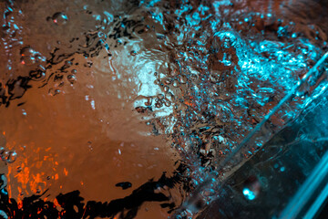 water texture rumbling chaos with bubbles created by air escaping outside in blue and red light