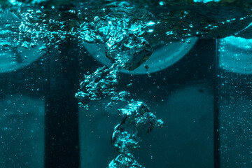 texture of the water is a rumbling chaos with bubbles created by the air escaping outside in the...