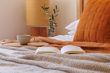 Reading a book in bed with a cup of tea