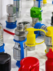 Brightly colored industrial fittings and connectors arranged on a clean surface in a workshop setting showcasing modern engineering tools