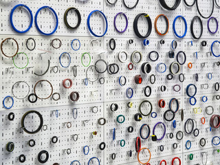 Colorful assortment of rubber seals displayed on a wall in a workshop for industrial applications