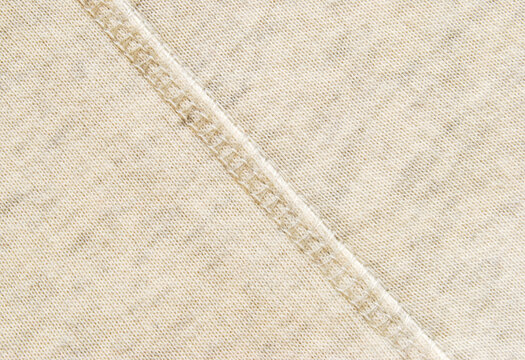 Soft beige cotton melange jersey fabric with a overlock seam detail in the center texture or background