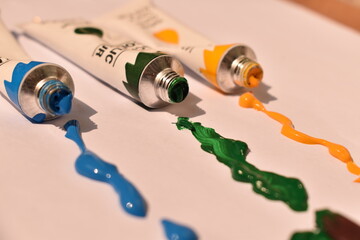 Assorted acrylic paint tubes with paint leaking out. Bright artistic chaos symbolizing creativity and expression.