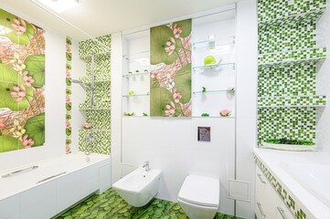 Bright bathroom with white tiles, lotus-themed art, and green mosaic accents. Features a tub,...