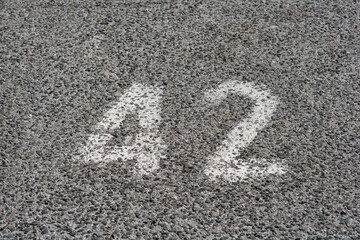 An aerial view shows the number 42 painted in white on a textured asphalt surface