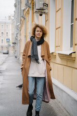 Obraz premium Confident Woman Walking Down City Street in Autumn