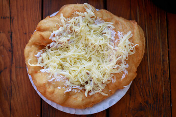 from above view of langos on a plate topped with cheese
