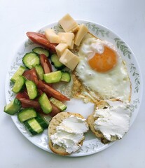 Nutritious breakfast plate with fried egg, vegetables, cheese and cream cheese toasts