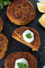 Veggie burger patties with sour cream on dark background. Top view. Healthy homemade vegan meat alternative.