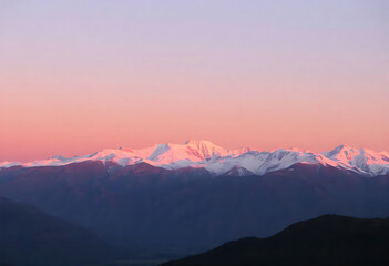 Fototapeta premium Majestic snow capped mountains silhouetted against a beautiful pink and purple sunset sky