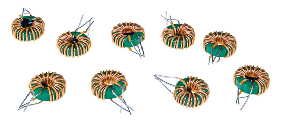 Set of passive electronic components transformers isolated on a white panoramic background. Closeup a group of toroidal inductors with spiral copper wire winding on green electromagnetic ferrite core.