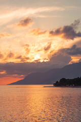 sunset on the seashore with a view of the mountains in makarska riviera croatia