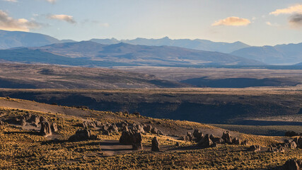 Rugged, brown terrain with unique rock formations under a clear sky. Los Bolillos, Neuquen, Argentina